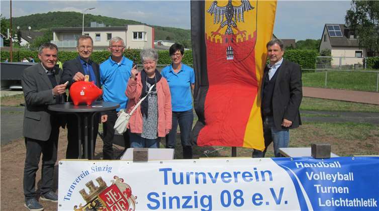 Ortsvorsteher Gunther Windheuser (l.) und Bürgermeister Andreas Geron (2. v.l.) füllten als die Ersten das „Sparschwein Stadionkopf“ des TV Sinzig. privat