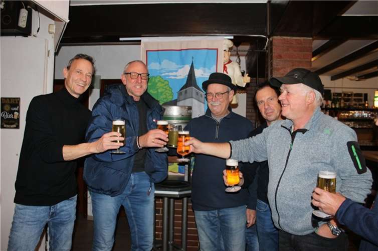 Ortsvorsteher Olaf Wulf beim traditionellen Fassanstich mit der Besucherschar Oedingens bei Leo. Daneben „Zachhäus“, vor seiner Verurteilung. Foto:privat