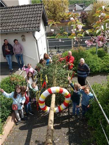 Ortsvorsteher und Vorsitzender der Bürgergesellschaft Stephan Hübinger (rote Jacke) schmückt mit den Kindern den Gimmiger Maibaum. Foto: Michael Wilke