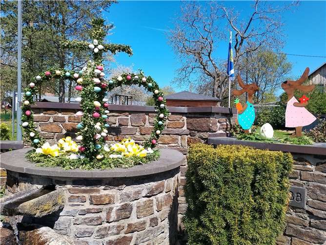 Osterkrone und Osterhasen schmücken den Brunnen vor der Pfarrkirche.  Foto: privat