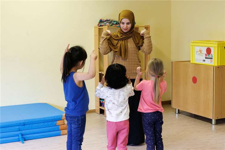 Pädagogik-Studentin Nurdan Aydin in der Kita Sonnenschein: Vormachen, Nachmachen, Nachsprechen und Bewegung hilft beim Sprechenlernen.  Foto: Petra Edel