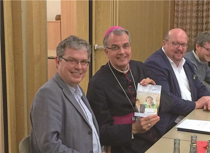 Pastor Kurp (li.) übergibt den neuen Pfarrbrief an Weihbischof Peters. privat