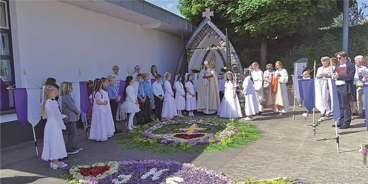 Pastor Kurp mit Messdienern und Erstkommunionkindern vor dem festlich geschmückten Altar am Dorfplatz  Privat