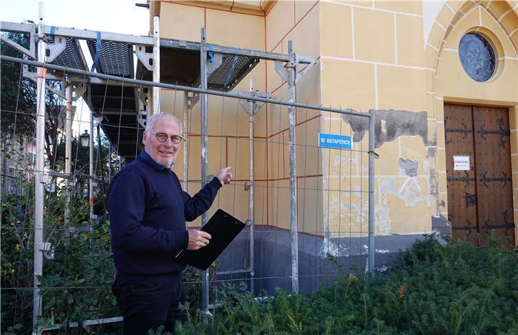 Paul Radermacher betrachtet den sanierten Nordteil mit den roten Quadermarkierungen. Rechts erkennt man noch unsanierte Flächen der Westseite.Foto: Weber