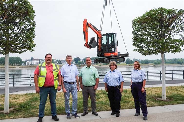 Per Kran wurde der kleine Bagger vor die Deichuferpromenade gesetzt und anschließend der Unrat abtransportiert. Ralf Seemann (2. von links) dankte Kai Povileit und Ziad Quire, Servicebetriebe Neuwied, sowie Susanne Korth und Brunhild Lauterborn, kommunaler Vollzugsdienst, und den weiteren Beteiligten für die zügige Entsorgung der vermeintlich gefährlichen Fässer und des sperrigen Unrats aus dem Flussbett.