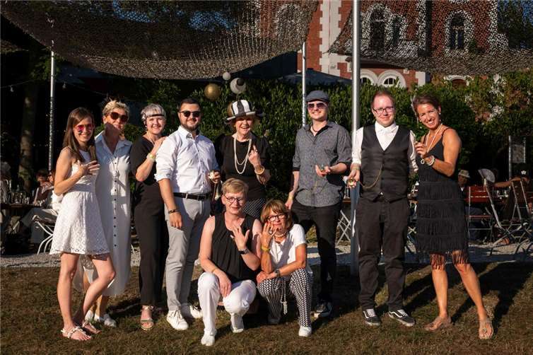 „Ein Jahrhundert voller Klang und Visionen“ Persönliche Hommage an die Gründer: Zur Überraschung der Geschäftsleitung von BECKER Hörakustik trug das Koblenzer Team des Unternehmens am Festtag Ringe und Taschenuhren mit Schwarz-Weiß-Fotos des Gründerpaares – ein besonderes Zeichen der Wertschätzung. Rechts im Bild: Eva Keil-Becker, Mitglied der Geschäftsführung. Foto: BECKER Hörakustik