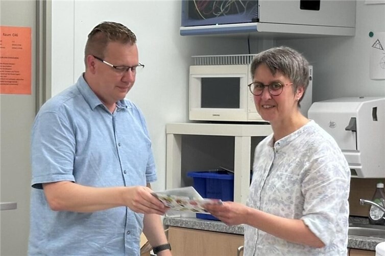 Personalrat Peter Roth verabschiedet Marion Bach mit einem Präsent.