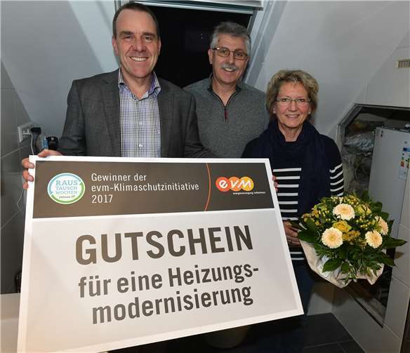 Peter Hehl von der evm überreicht Bärbel und Hans-Georg Schlich den Gutschein über die Heizungsmodernisierung, der einen Wert von 5.000 Euro hat.evm/Seydel