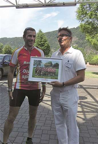 Peter Kreilkamp, Mitorganisator der Radtour, übergibt dem ärztlichen Leiter Dr. Joachim Lux zum Dank ein Foto.privat