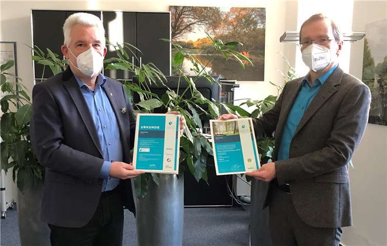 Peter Krupp (Geschäftsführer KRUPP Druck)) übergibt die Urkunden für die gepflanzten Bäume sowie die Treibhausgas-Kompensation der Amtlichen Bekanntmachungen an Bürgermeister Andreas Geron. Foto: Linda Krupp