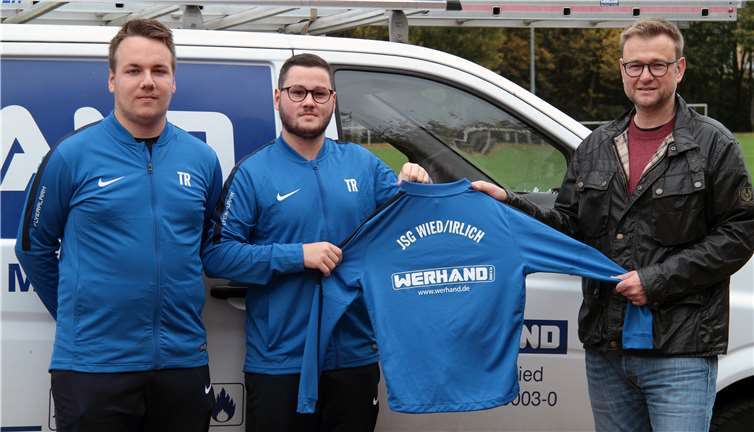 Peter Werhand (rechts) übergibt Philipp Pfeiffer (links) und Marcos Becker, den beiden Trainern der D-Jugend von der JSG Wied/Irlich, die neuen Trainingsanzüge und Shirts. privat