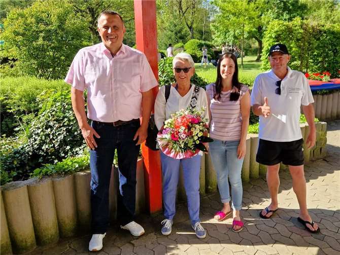 Peter Wilkes, Daniela Friedrichs und Schwimmmeister Frank von Schmidt sind begeistert, dass die aktuelle Badesaison unter so tollen Bedingungen begonnen hat und begrüßen Astrid Franke (2. v. l.) aus Koblenz als ersten Badegast der Saison mit einem Blumenstrauß. Foto: Sebastian Friedrichs