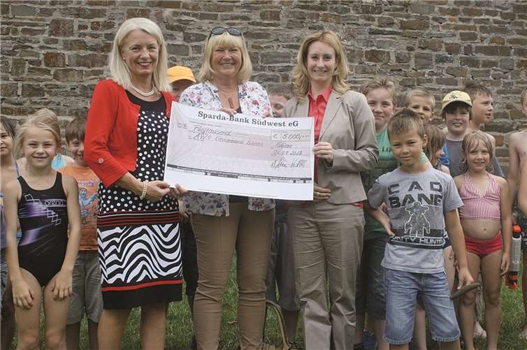 Petra Hahn, Gebietsleiterin der Sparda-Bank Südwest eG, überreichte den Scheck an die die AWO-Vorsitzende, Christiane Heinrich-Lot. Auch die Kinder fanden die Aktion toll. privat