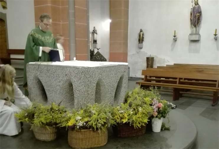 Pfarrer Alexander Kurp beim Segnen der Kräutersträuße.privat