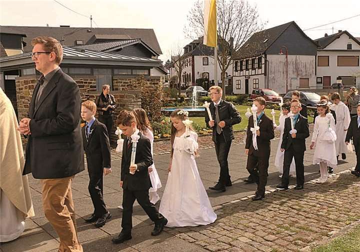 Pfarrer Heinrich Ant und Gemeindereferent Matthias Beer geleiten die Kommunionkinder in die Pfarrkirche.