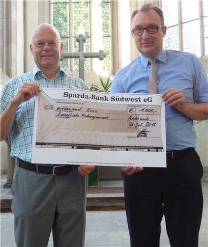 Pfarrer Jürgen Gundalin und Henning Oster, Vertreter der Sparda-Bank Südwest, bei der Scheck-Übergabe.privat