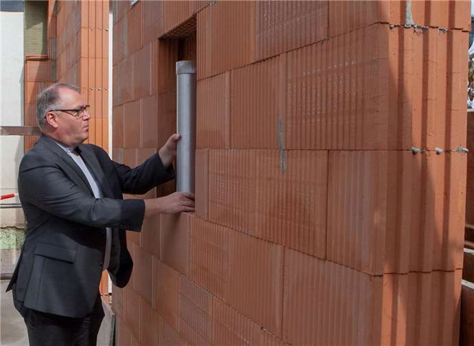 Pfarrer Michael Hoßdorf verstaute die Plombe mitTageszeitungen, Bauplänen, einem Kinderbild und denaktuellen Euro Münzen in der Wand des Erweiterungsbaus.