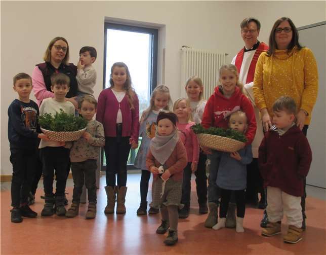 Pfarrer Norbert Missong und Erzieherinnen mit einigen Kindergartenkindern und den gesegneten Palmzweigen. Foto: privat