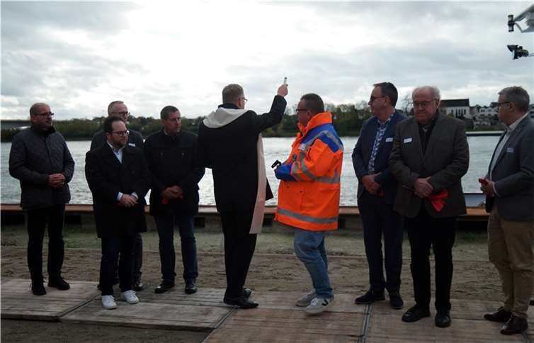 Pfarrer Pastor Klupsch segnet die modernisierte Kaimauer im Rheinhafen Bendorf.
