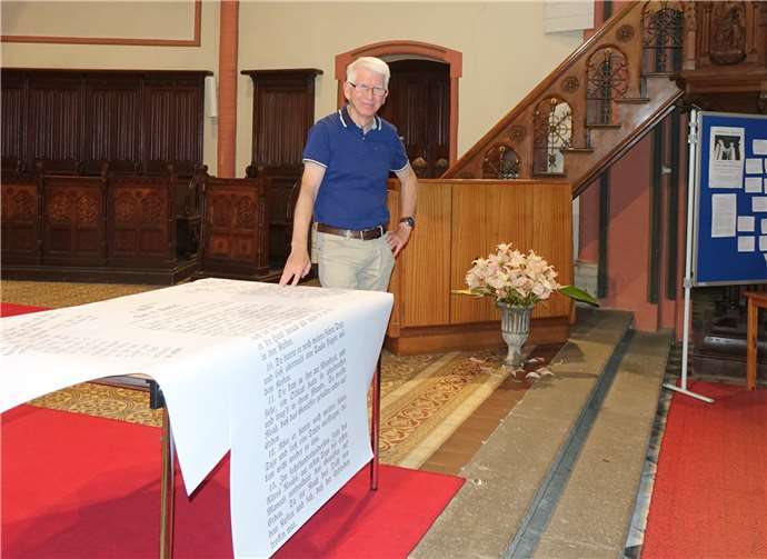 Pfarrer Werner Zupp mit Sintfluttext und der Pinnwand. Foto: Jürgen Grab