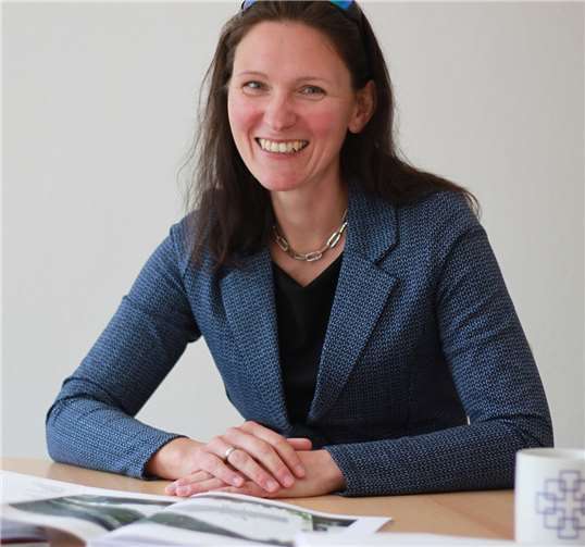 Pfarrerin Anne Pollmächer zeigt die Pläne für die Wohnbebauung auf dem Lutherkirchen-Gelände.