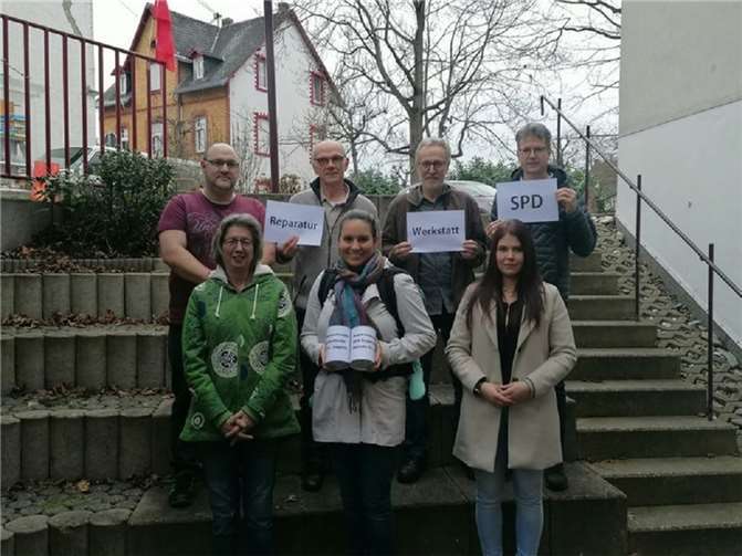 Pfarrerin Natalie Wilcke (Mitte) mit den Spendendosen 2022 und 2023, sowie die Handwerker der Reparaturwerkstatt.  Foto: SPD Engers