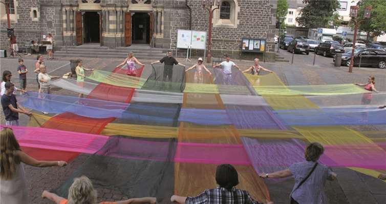 Pfingsten 2014 auf dem Vorplatz der Herz-Jesu-Kirche: Bunte, miteinander verwobene Tücher als Zeichen der Verbundenheit und Vielfalt zwischen den Kirchen.privat