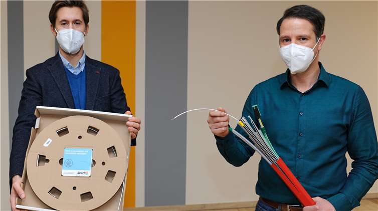 Philipp Da Costa (links) zeigt das im Preis enthaltene Paket, um vom Netzabschluss eine Leitung zum eigenen Router zu ziehen. Wie das in der Straße aussieht, zeigt Teamleiter Christoph Kröner: ein Bündel an Lehrröhrchen, in die die Glasfaser eingezogen bzw. in einem speziellen Verfahren „eingeblasen“ werden. Damit können die SWN die fortschrittlichste Technologie zur Datenübertragung liefern.Foto: SWN