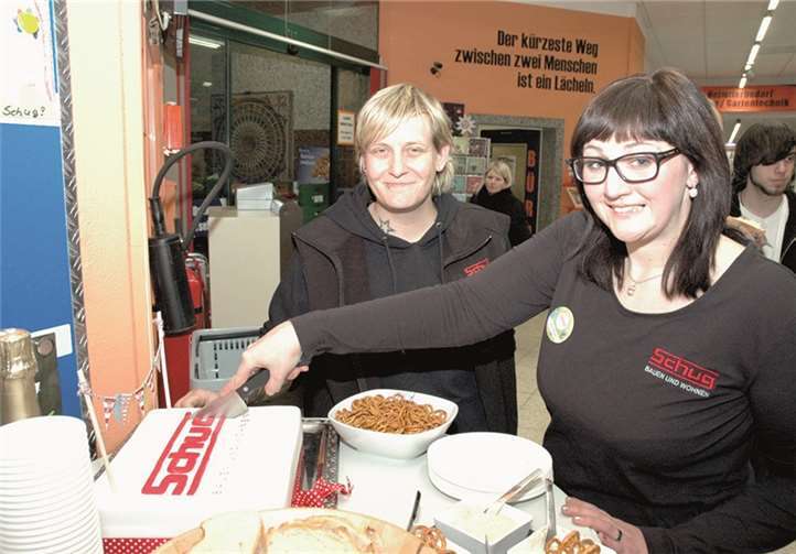 Pia Schug (l.) und Marktleiterin Kim Faust schneiden zur Eröffnung eine eigens kreierte Torte an.
