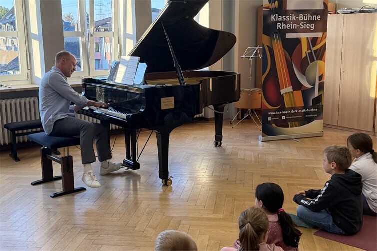 Pianist Markus Kreul am Flügel beim musikalischen Erlebnis „Zauberkasten Klavier“ in der Katholischen Grundschule Meckenheim. Als Musiker und Moderator führte er durch das 45-minütige Programm.