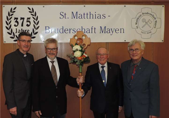 „Pilgerstaffelstab“ übergeben. Rolf Keuser folgt auf Heinz Schäfer, der im Rahmen der Versammlung zum Ehrenbrudermeister ernannt wurde. Präses Dechant Matthias Veit und der stellvertretende Brudermeister Dieter Preß freuen sich auf die Zusammenarbeit. Dennis Falterbaum