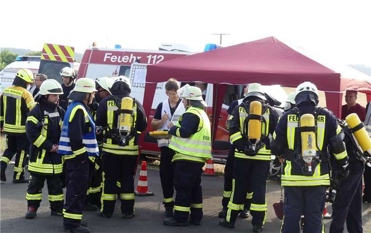 Planungsabstimmung mit den Kräften der FFW-Führungsstaffel vor deren Einsatzfahrzeug im Vorfeld der Übung.