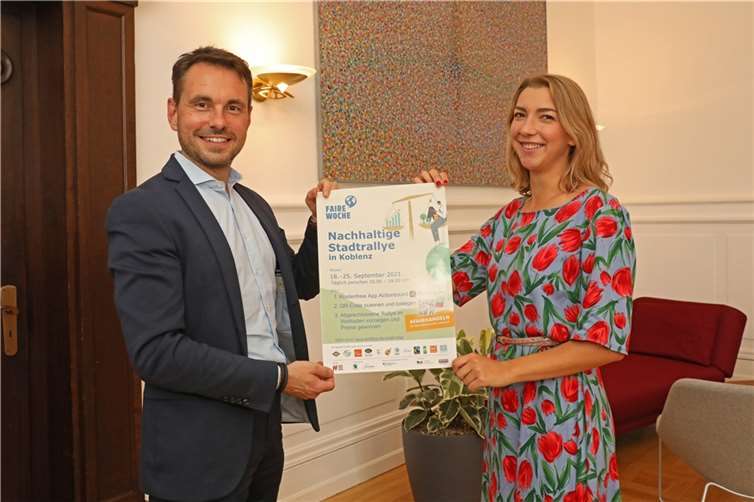 Präsentieren das Plakat zur nachhaltigen Stadtrallye in Koblenz: Oberbürgermeister David Langner und Lea Zimmermann, Sprecherin der Steuerungsgruppe Fair Trade Stadt Koblenz.Quelle: Stadt Koblenz