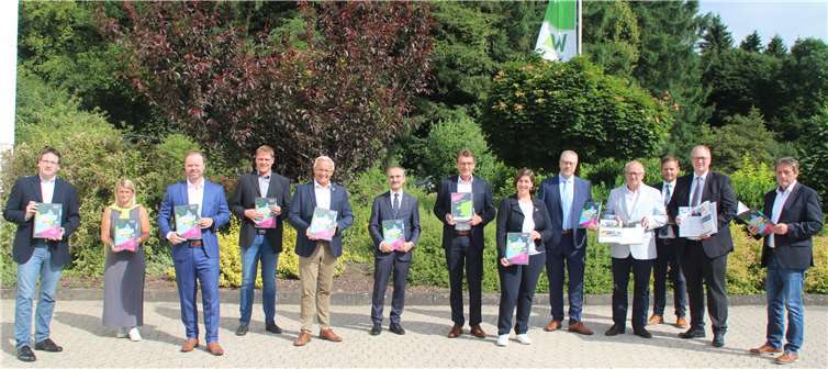 Präsentierten die neue Ausbildungsfibel „Westerwälder Naturtalente“ (v.l.n.r.): Harald Schmillen (Geschäftsführer WFG Kreis Neuwied), Sandra Köster (Vorständin, Wir Westerwälder), Patrick Schumacher (Attentio, Hachenburg), Lars Kober (Leiter Wirtschaftsförderung Kreis Altenkirchen), Achim Hallerbach (Landrat Kreis Neuwied), Dr. Hermann-Josef Richard (Sparkasse Neuwied), Dr. Andreas Reingen (Sparkasse Westerwald Sieg), Katharina Schlag (Geschäftsführerin WFG Westerwaldkreis), Stefan Maschel (Personalchef Firma Vecoplan), Dr. Peter Enders (Landrat Kreis Altenkirchen), Sven Becker (Teamleiter Aus- und Weiterbildung Schütz Group), Jürgen Marx (Leiter HR Schütz-Group), Achim Schwickert (Landrat Westerwaldkreis).Foto: Wir Westerwälder