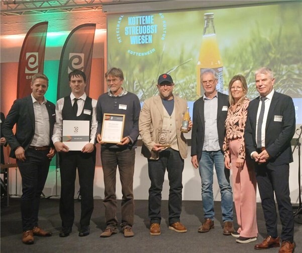 Preisverleihung des EIFEL Award 2025 mit (v.l.n.r.) Markus Ramers (Landrat Kreis Euskirchen und Präsident der Zukunftsinitiative Eifel), Philipp Diehl (Mosterei Diehl/Fruchtsaft Schwaab), Christoph Vanberg (Obstbaumpfleger), Prof. Dr. Andreas Hesse (1. Vorsitzender der Natur- und Kulturinitiative Streuobstwiesen Kottenheim e.V.), Karl-Josef Schwaab (Mosterei Diehl/Fruchtsaft Schwaab), Julia Gieseking (Landrätin Landkreis Vulkaneifel) und Gregor Freches (Minister für Kultur, Sport, Tourismus und Medien der Deutschsprachigen Gemeinschaft Belgien).