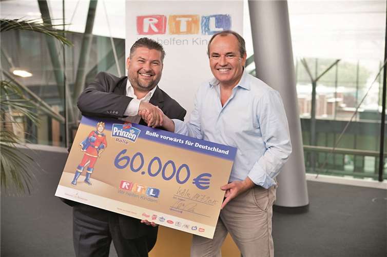 Pressesprecher Peter Gries überreicht den Scheck in Höhe von 60.000 Euro an Wolfram Kons, Moderator der RTL-Sendung „Guten Morgen Deutschland“ sowie stellvertretender Vorsitzender der Stiftung RTL – Wir helfen Kindern e.V. RTL