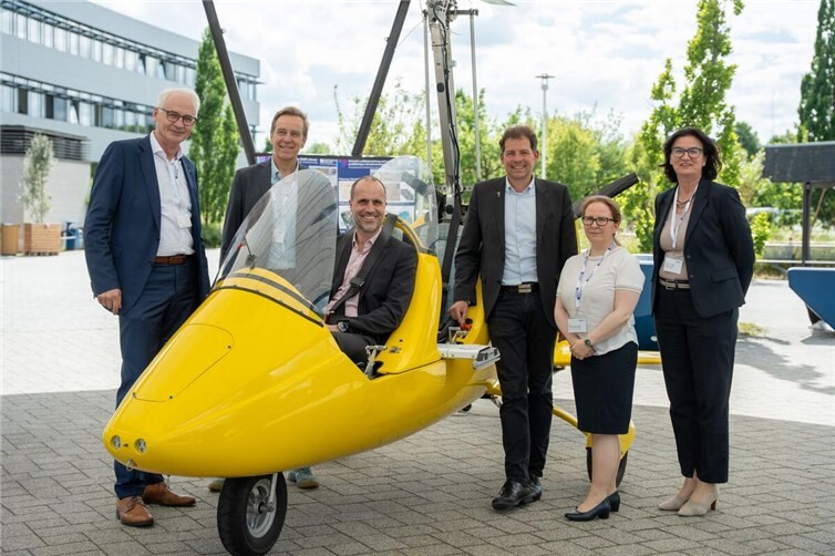 Probesitzen im Tragschrauber beim Tag der Forschung: Minister Clemens Hoch, Ministerium für Wissenschaft, Weiterbildung und Gesundheit (MWG). Außerdem auf dem Bild: Prof. Dr. Karl Stoffel, Präsident der Hochschule Koblenz und Prof. Dr. Jens Bongartz, Fachbereich Mathematik, Informatik, Technik (links neben dem Tragschrauber v.li.n.re.) sowie Dr. Felix Streiter, Geschäftsführer der Carl-Zeiss-Stiftung, Dr. Katrin Zaborowski, Ministerium für Wissenschaft, Weiterbildung und Gesundheit und Prof. Dr. techn. Antje Liersch, Vizepräsidentin für Forschung der Hochschule Koblenz (rechts neben dem Tragschrauber v.li.n.re.)