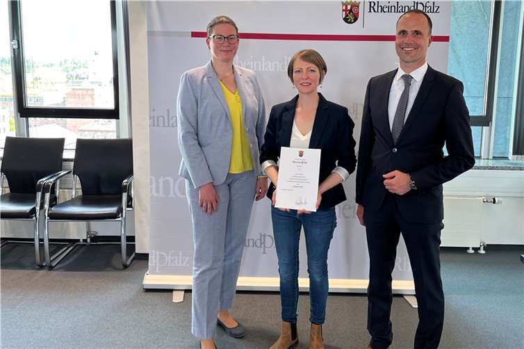 Prof. Dr. Constanze Juchem-Grundmann und Minister Clemens Hoch gratulieren Lena Friedrich (Mitte) zur Auszeichnung ihrer exzellenten Lehre. Die zweite Preisträgerin der Universität, Annika Feyen, konnte nicht an der Verleihung teilnehmen.  Foto: MWG
