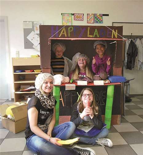 Projektkinder und Danielle Schmidt mit dem selbst gebauten „HAPPYLADEN“.privat