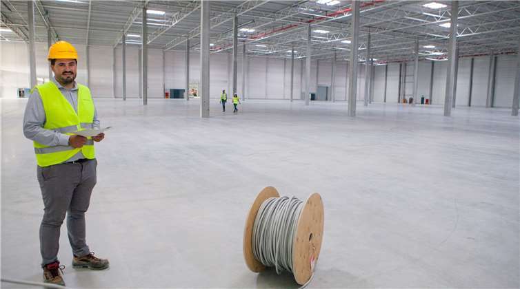 Projektleiter Simon Geisel erläutert, dass 15 Fußballplätze in jedes der beiden großen Lagergebäude von DHL Supply Chain und Eaton im Rheinbacher „Wolbersacker“ passen.