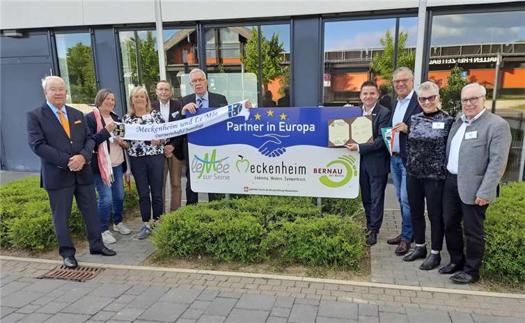 Rahmen das neue Städtepartnerschaftsschild am Rathaus ein, von links: Jens Biesterfeldt, Dr. Brigitte Kuchta, Brigitte Schneider, Heiner Wurm, Dr. Reinhardt Thiel, (alle Bürgerverein) Bürgermeister Holger Jung, Burchard Kraus von der Bürgerstiftung sowie Gerhild Fiegl und Peter Fiegl (beide Bürgerverein). Foto: Bürgerstiftung Meckenheim