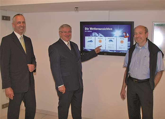Raimund Lehmkühler (v. l.), Oberbürgermeister Prof. Dr. Joachim Hofmann-Göttig und Joachim Deboeser freuen sich über das neue Solar-Display im Foyer der Rhein-Mosel-Halle.