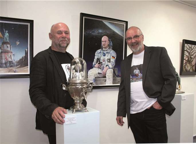 Rainer Sperl (l.) und Eberhard Marx nehmen Laika im Samowar und das Portrait des Astronauten Alexander Gerst in ihre Mitte.HG