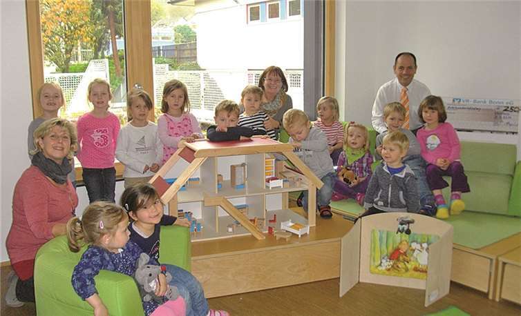 Ralf Heyden (hinten re.) freut sich mit den kleinen „Glühwürmchen“ und deren Betreuerinnen Ute Siebert (vorne li.) und Helga Kaiser (hinten Mitte) über das schöne Puppenhaus. privat