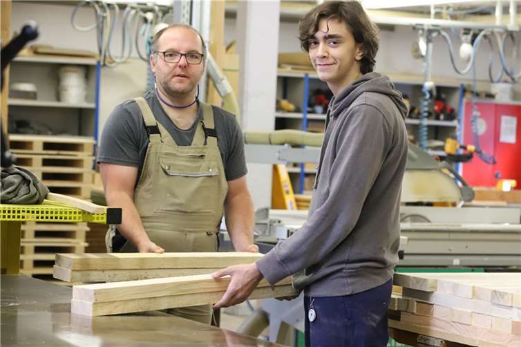 Ramon Leif (rechts), Auszubildender bei Niesmann+Bischoff, lernt die Arbeit in der Schreinerei der Caritas Werkstätten in Polch kennen.