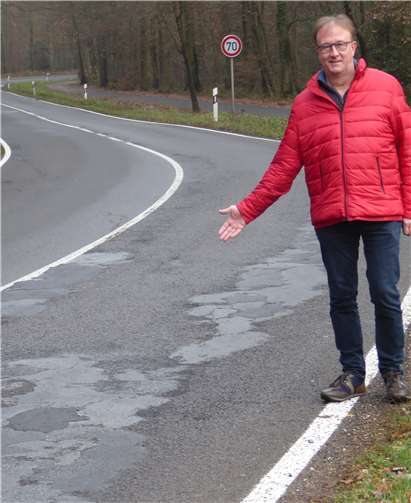 Ratsherr Jörg Meyer an der maroden Fahrbahn der L113 bei Merzbach. Privat