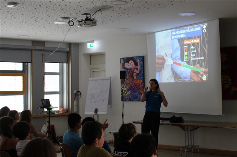 Referentin Marieanna Forst veranschaulichte den Schülerinnen und Schülern, wie man mittels eines MUAC-Bandes eine Mangelernährung bei unter Fünfjährigen diagnostiziert.