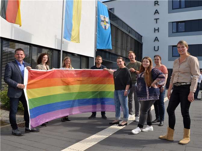 Regenbogenfahne im Mittelpunkt: Bürgermeister Holger Jung (links) und seine Mitarbeitenden zeigen Flagge. Foto: Stadt Meckenheim