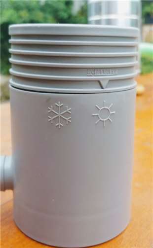 Regensammler aus Kunststoff. Über die Symbole Sommer/Winter wird der Wasserabfluss geregelt: Von Frühling bis Herbst über den seitlichen Stutzen und Schlauch direkt in den Garten, im Winter über das Fallrohr.