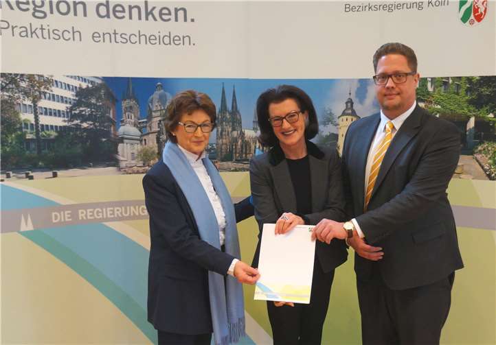 Regierungspräsidentin G. Walsken (Mitte), Bürgermeisterin R. Offergeld und Beigeordneter S. Christian freuen sich über den Förderbescheid für die Gemeinde Wachtberg.  Bezirksregierung Köln